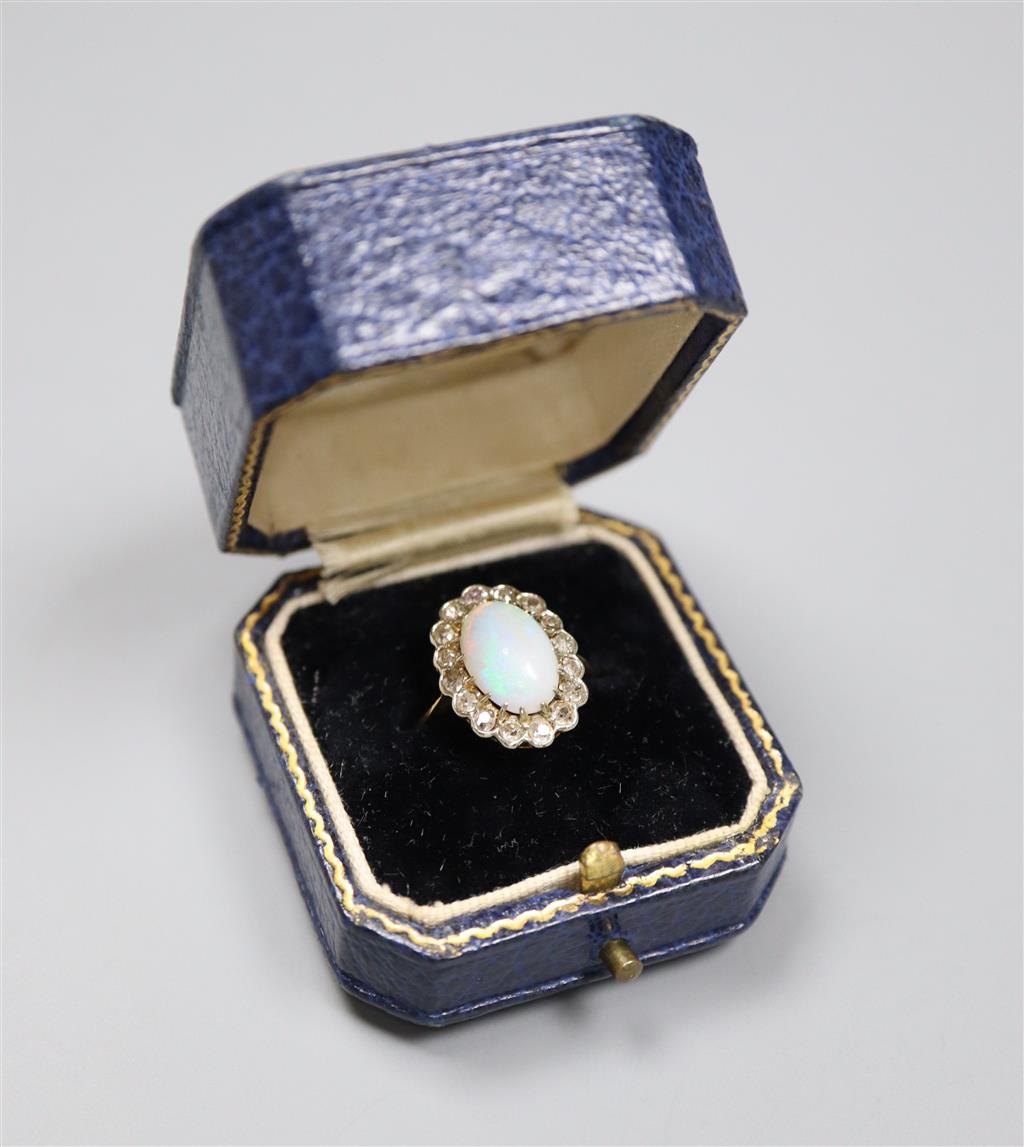 An early to mid 20th century 18ct, white opal and diamond set oval cluster ring, size K, gross 3.1 grams.